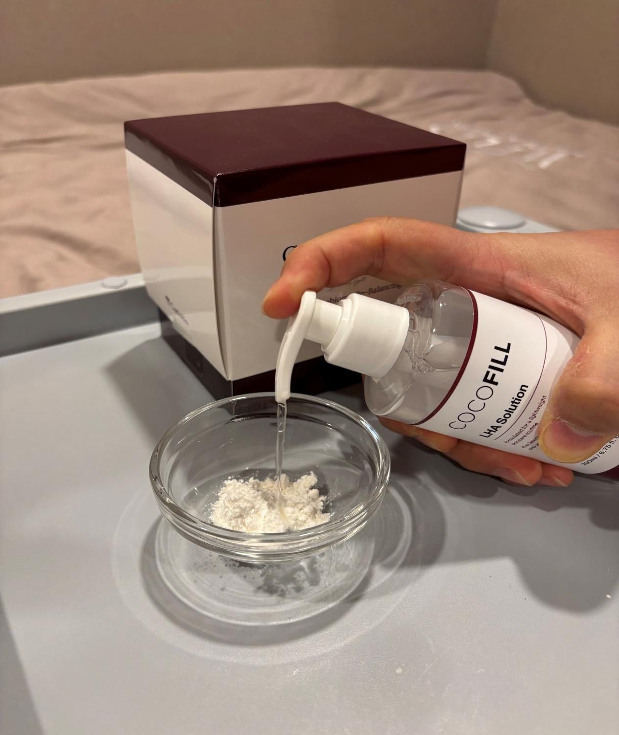 LHA solution being added to a glass bowl containing CocoBiome powder